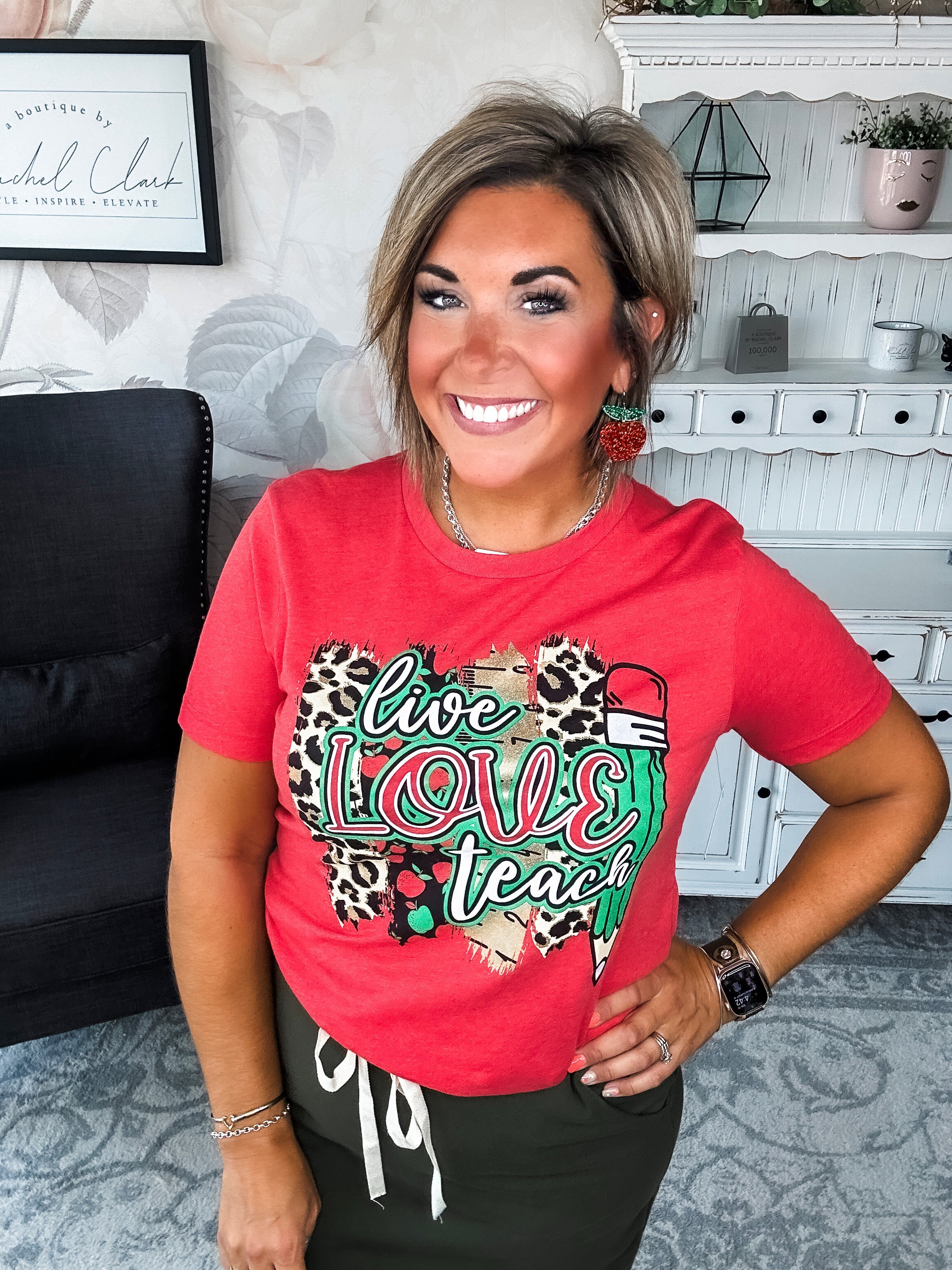 Woman wearing a red t-shirt with 'live love teach' design.