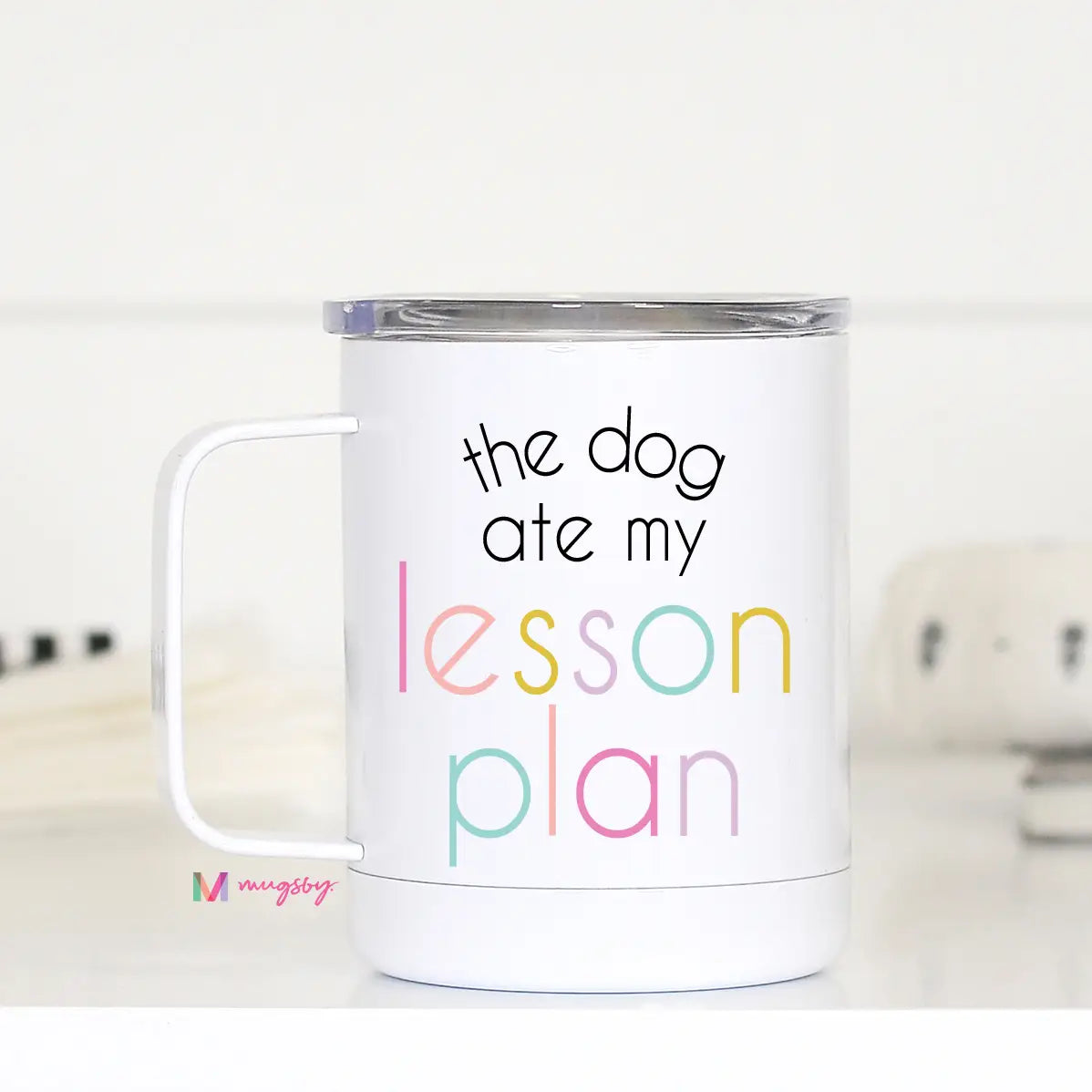 Insulated coffee mug with lid that reads 'the dog ate my lesson plan' in black and colorful letters.