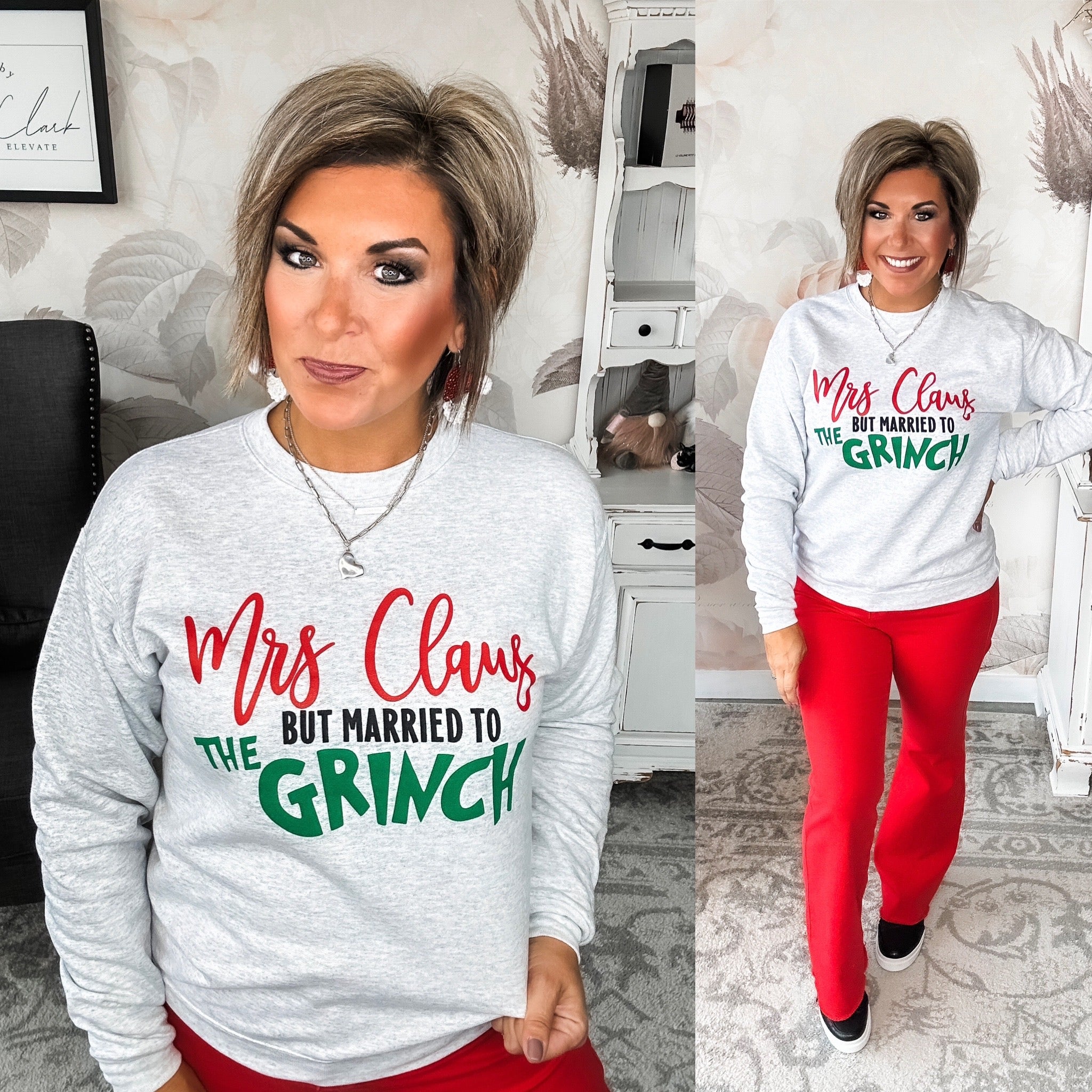A woman wearing a heather grey sweatshirt with the text 'Mrs Claus but married to the Grinch' in red and green.