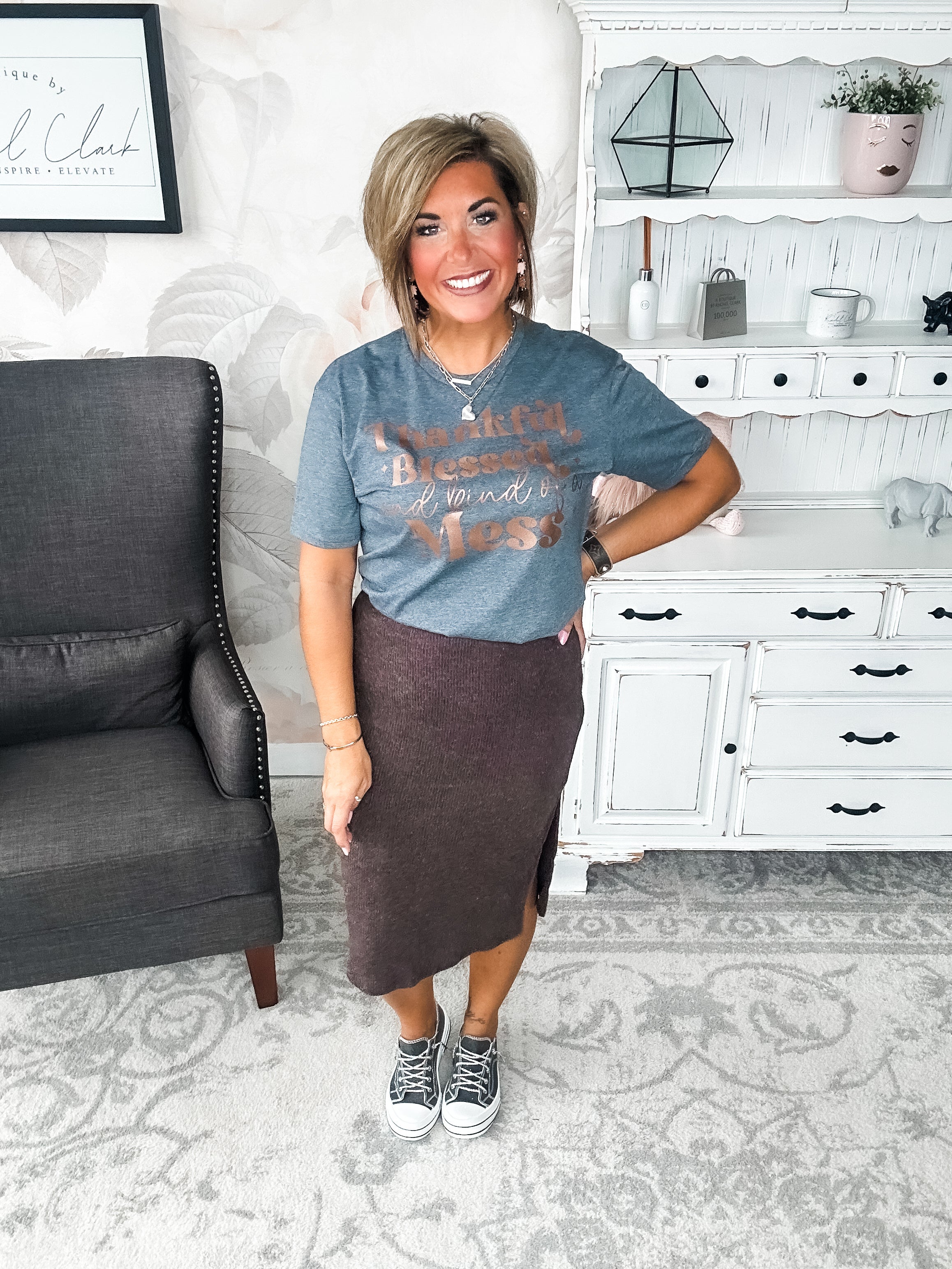 A woman wearing a grey t-shirt with the text 'Thankful Blessed and kind of a Mess' written in rose gold foil print.