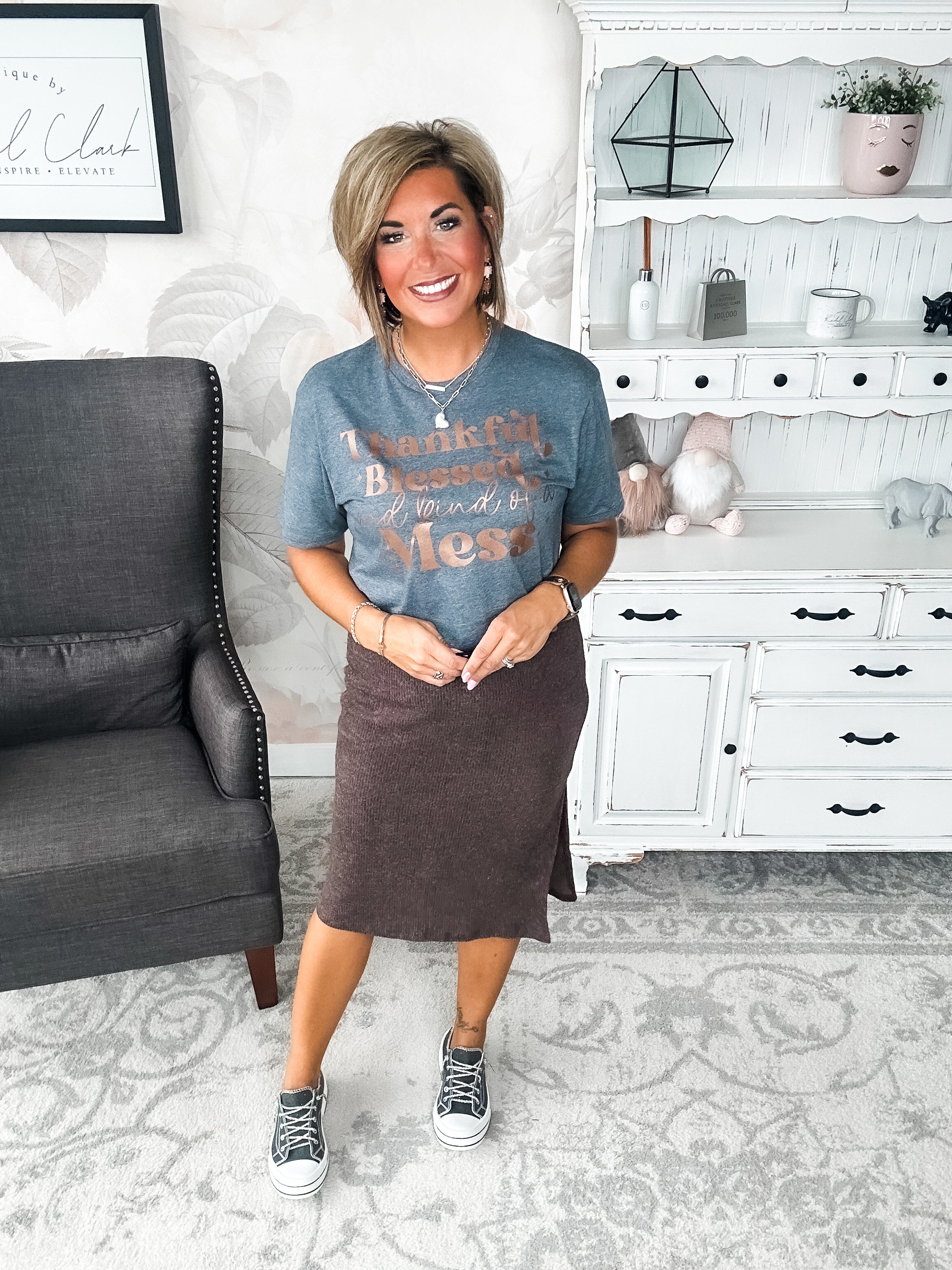 A woman wearing a grey t-shirt with the text 'Thankful Blessed and kind of a Mess' written in rose gold foil print.