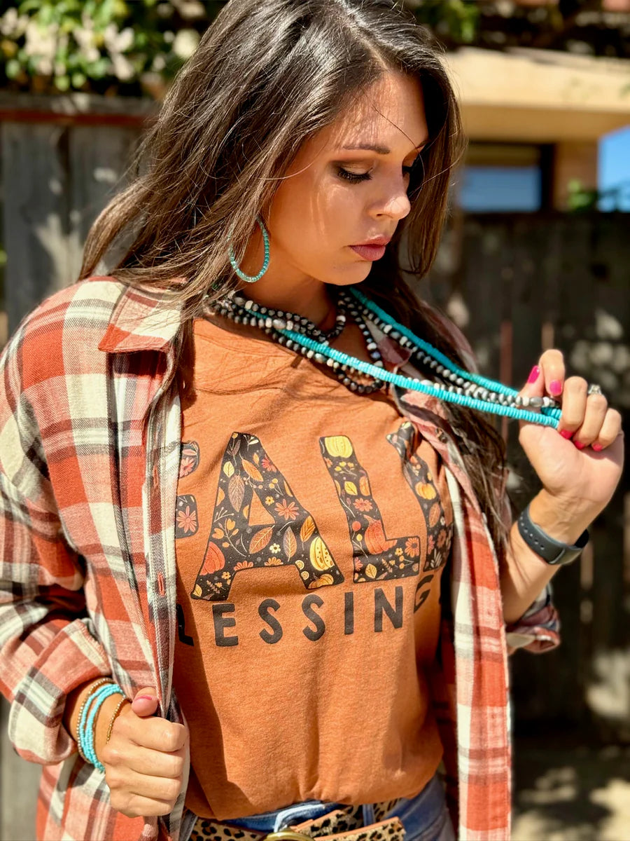 Woman wearing an orange t-shirt with 'Fall Blessings' with a leaf design.