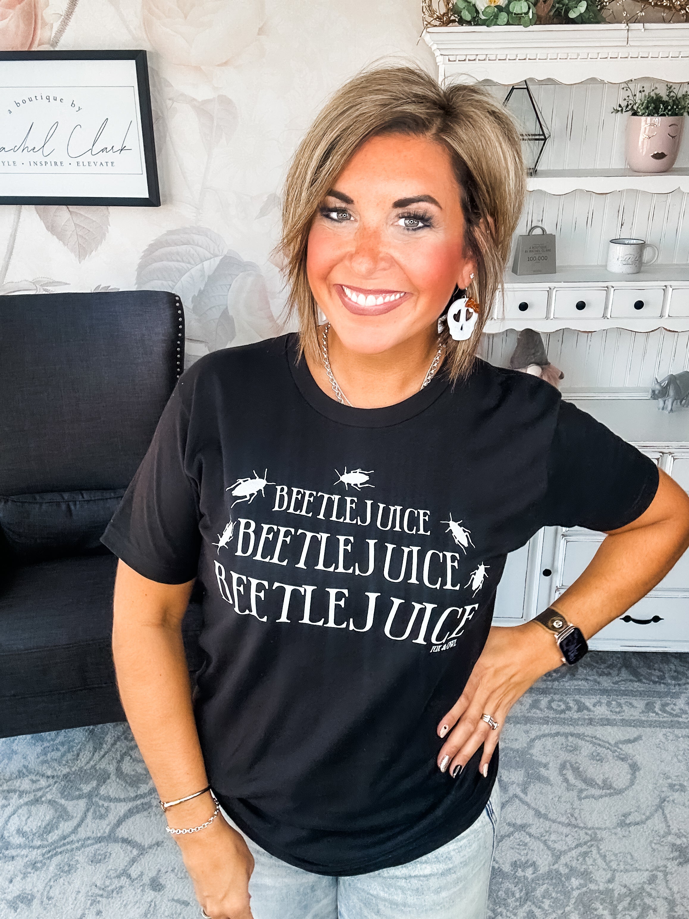 Woman wearing a black t-shirt that reads' Beetlejuice, Beetlejuice, Beetlejuice' with a beetle graphic design.
