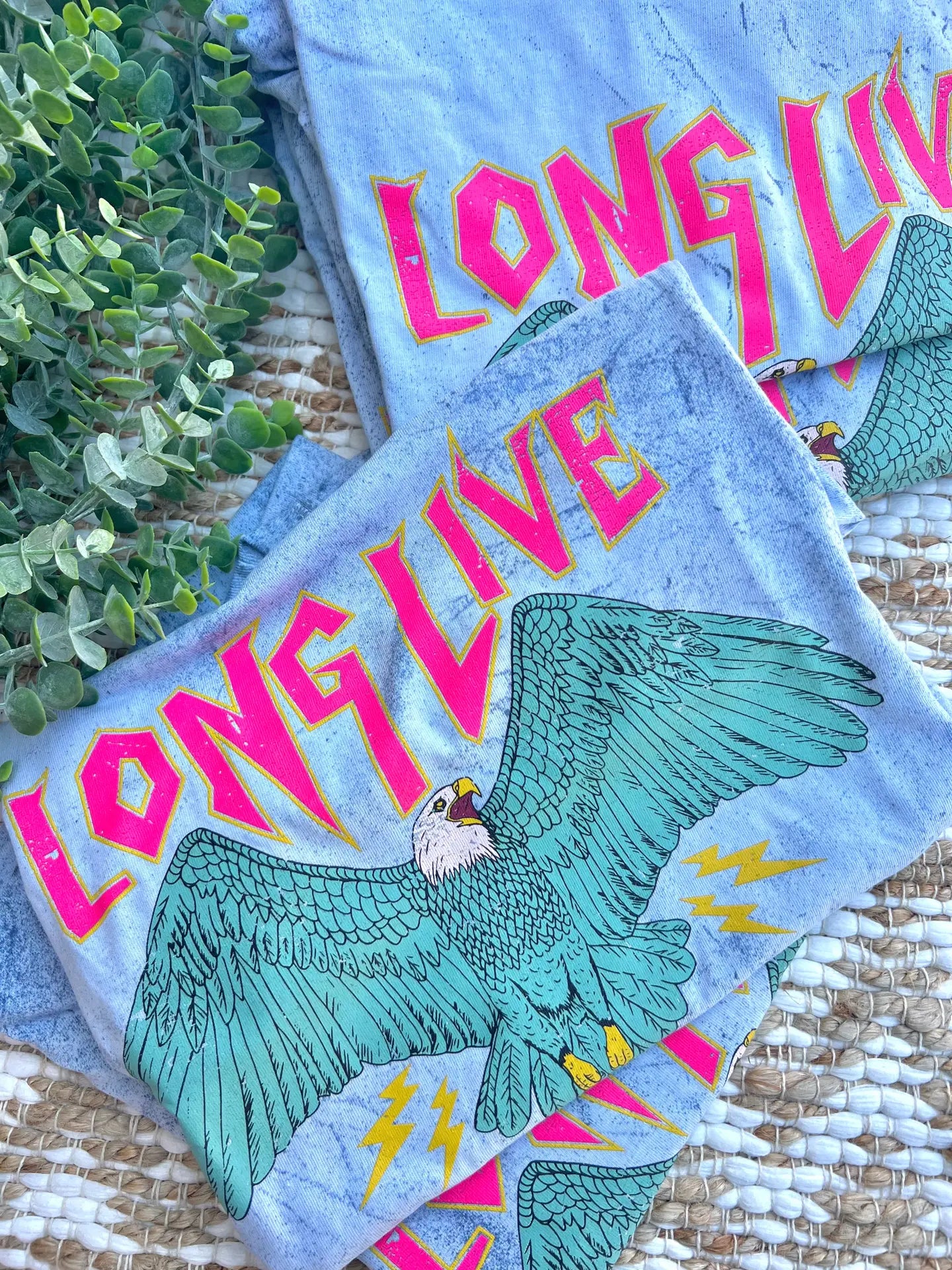 A crew-neck, short-sleeve graphic tee with the phrase 'LONG LIVE AMERICA' printed on it, in a bleached blue color.