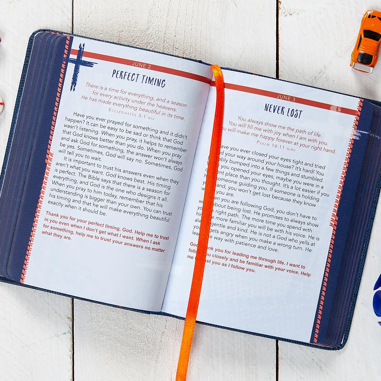 Devotional opened to a page titled "Perfect Timing" and "Never Lost" laying on a white wooden surface.