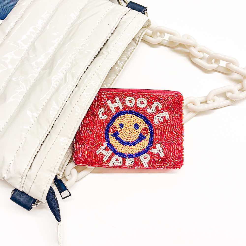 A red coin purse with decorative seed beadwork including a smiley face and the text 'CHOOSE HAPPY'.