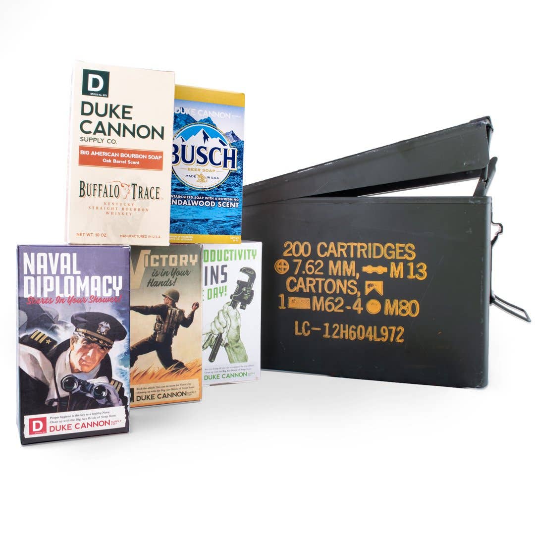 An ammo can with 5 Big Ass Bricks of soap displayed in front of it. Naval Diplomacy, Victory, Productivity, Busch Beer and Buffalo Trace Bourbon.