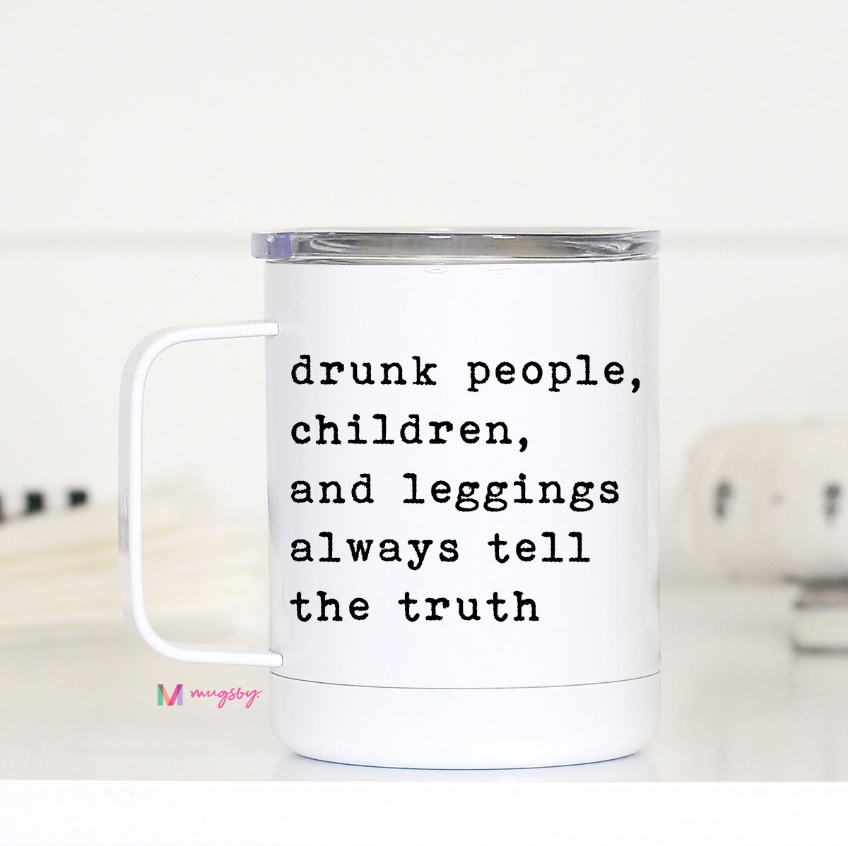 A white travel mug with a handle, featuring a black printed text that reads 'drunk people, children, and leggings always tell the truth'.