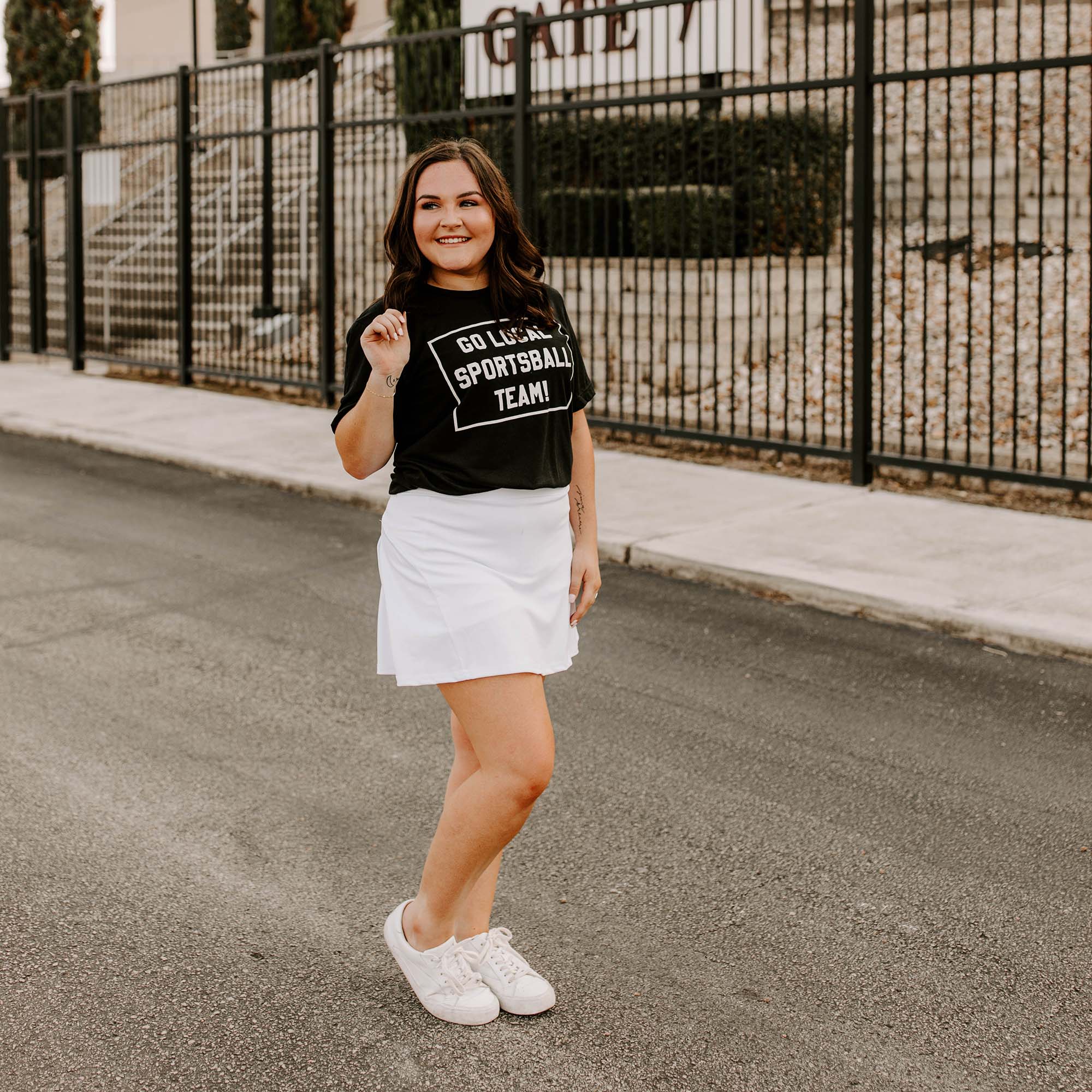 Woman wearing a black t-shirt with 'GO LOCAL SPORTSBALL TEAM!' text in white.