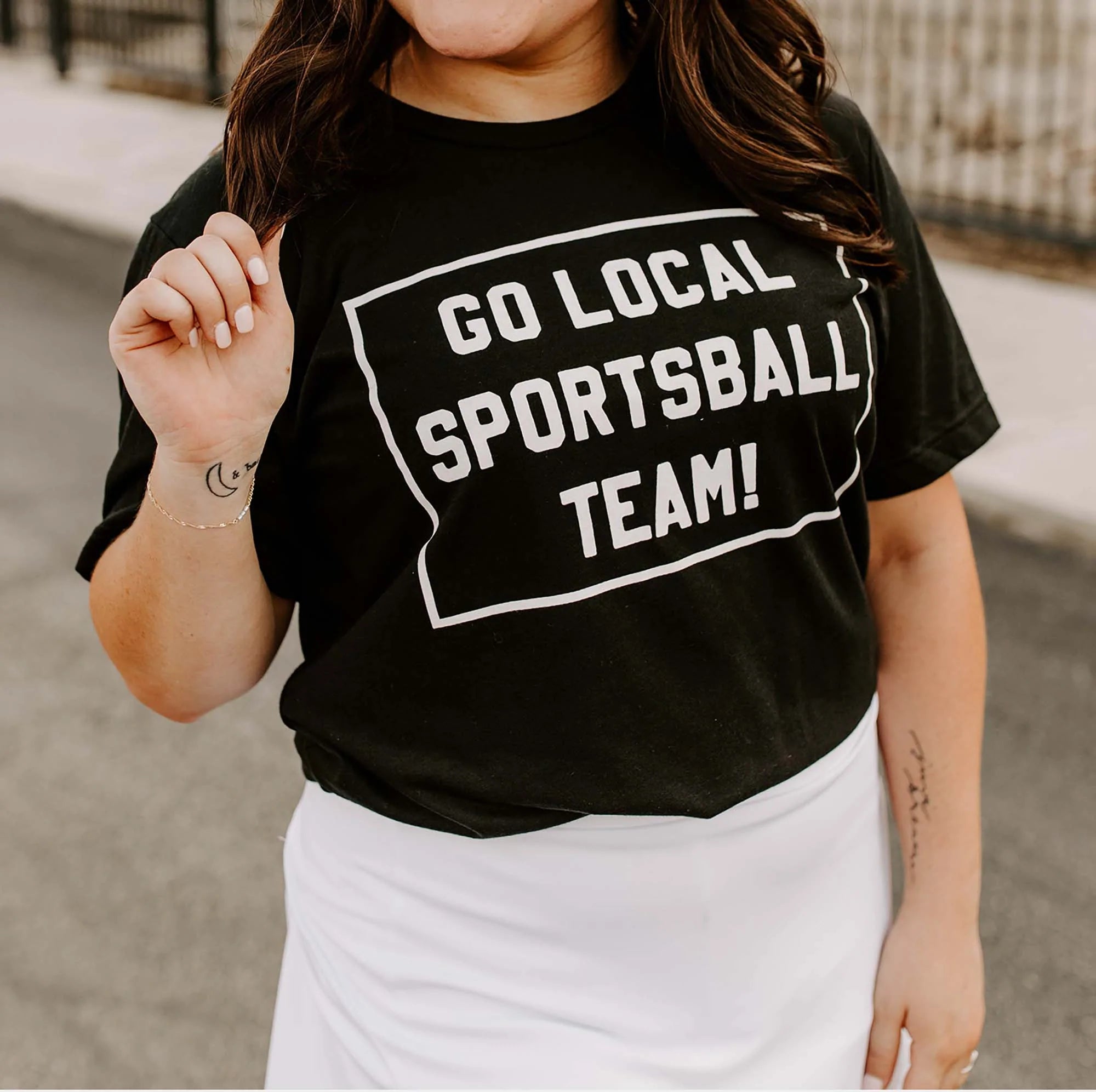 Woman wearing a black t-shirt with 'GO LOCAL SPORTSBALL TEAM!' text in white.