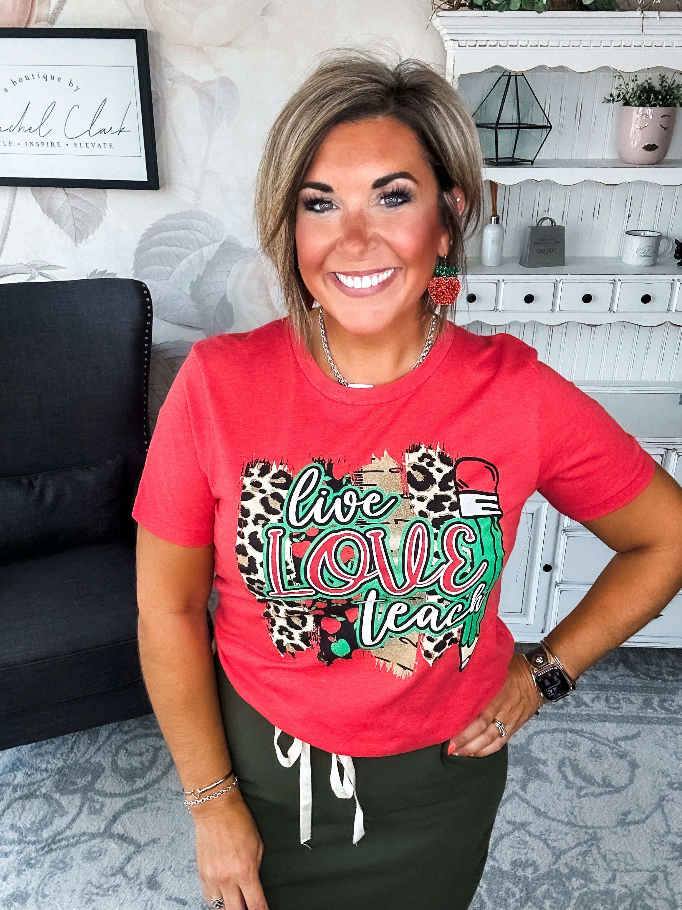 Woman wearing a red t-shirt with 'live love teach' design.