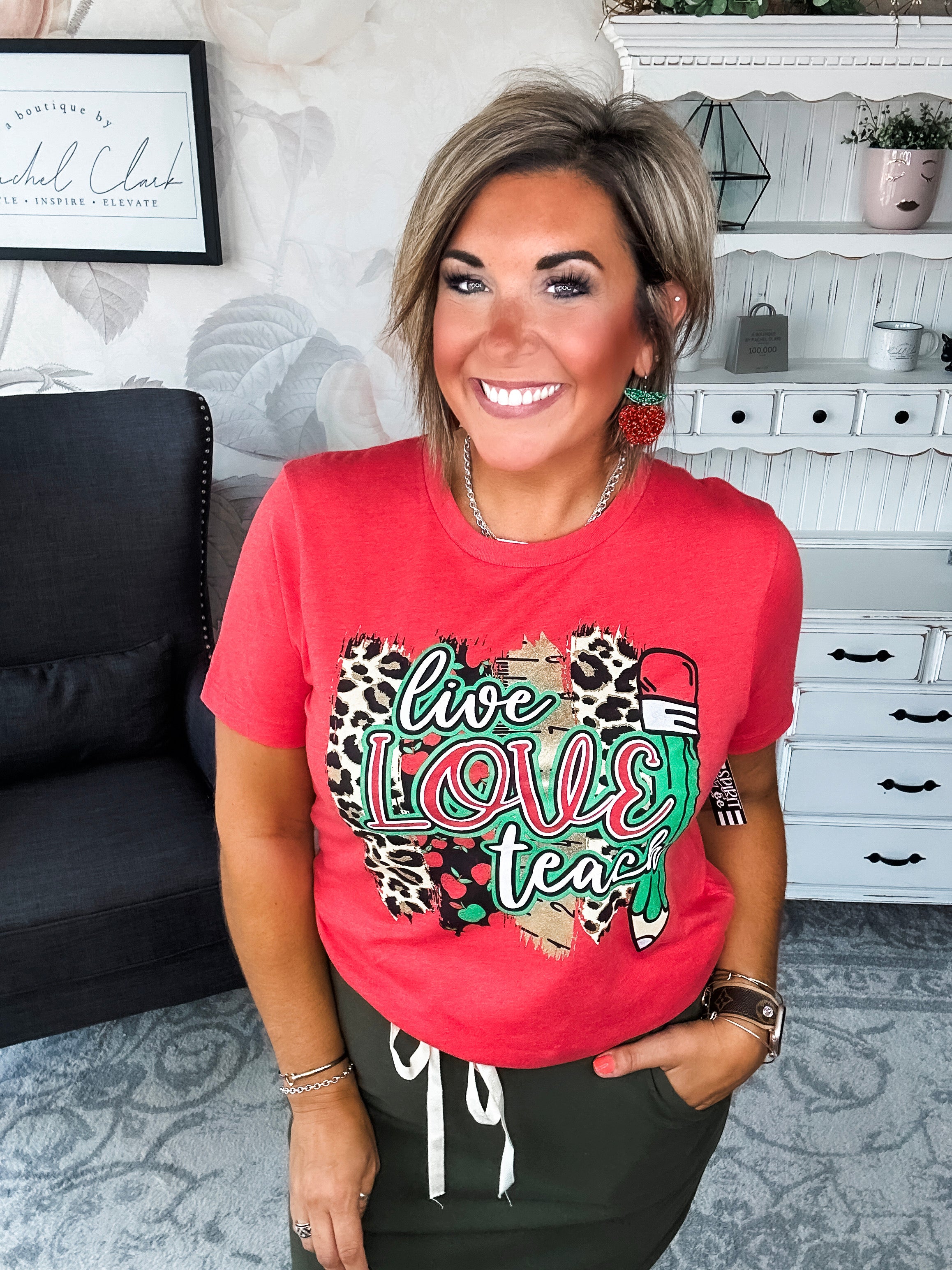 Woman wearing a red t-shirt with 'live love teach' design.