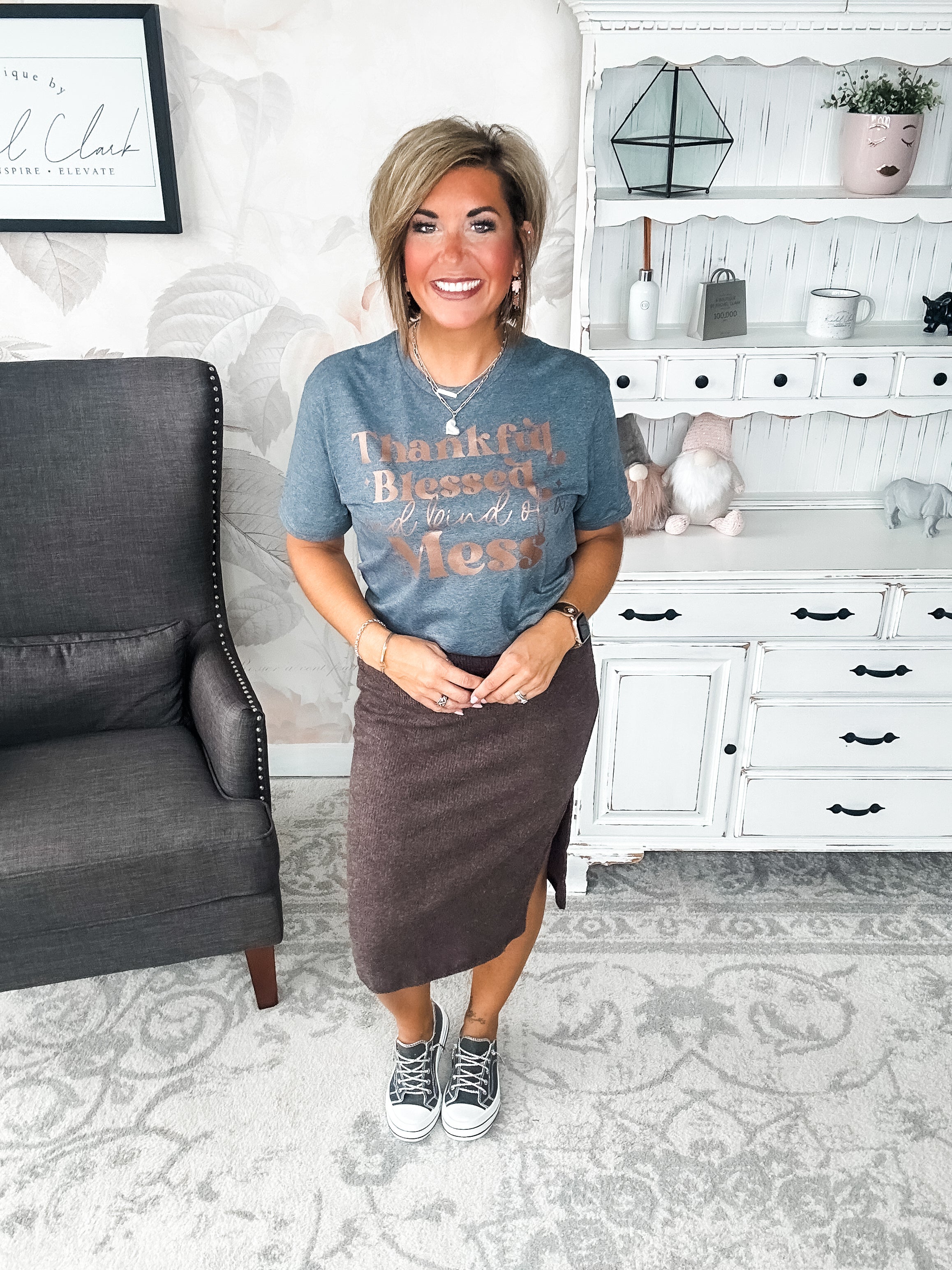 A woman wearing a grey t-shirt with the text 'Thankful Blessed and kind of a Mess' written in rose gold foil print.