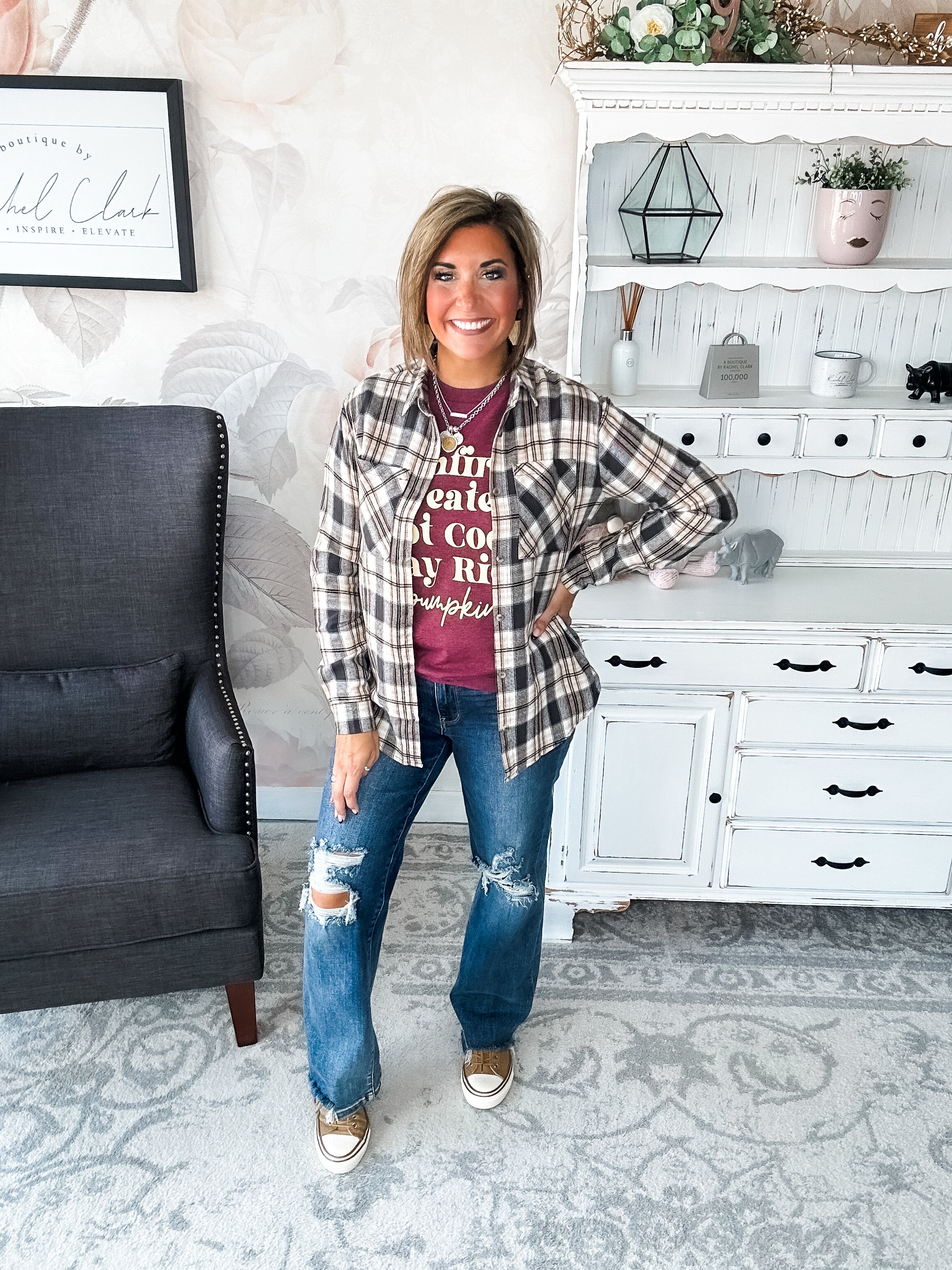 Woman wearing a maroon t-shirt that reads,  'Bonfires, Sweaters, Hot cocoa, Hay Rides and Pumpkins.' written in a cream text. 