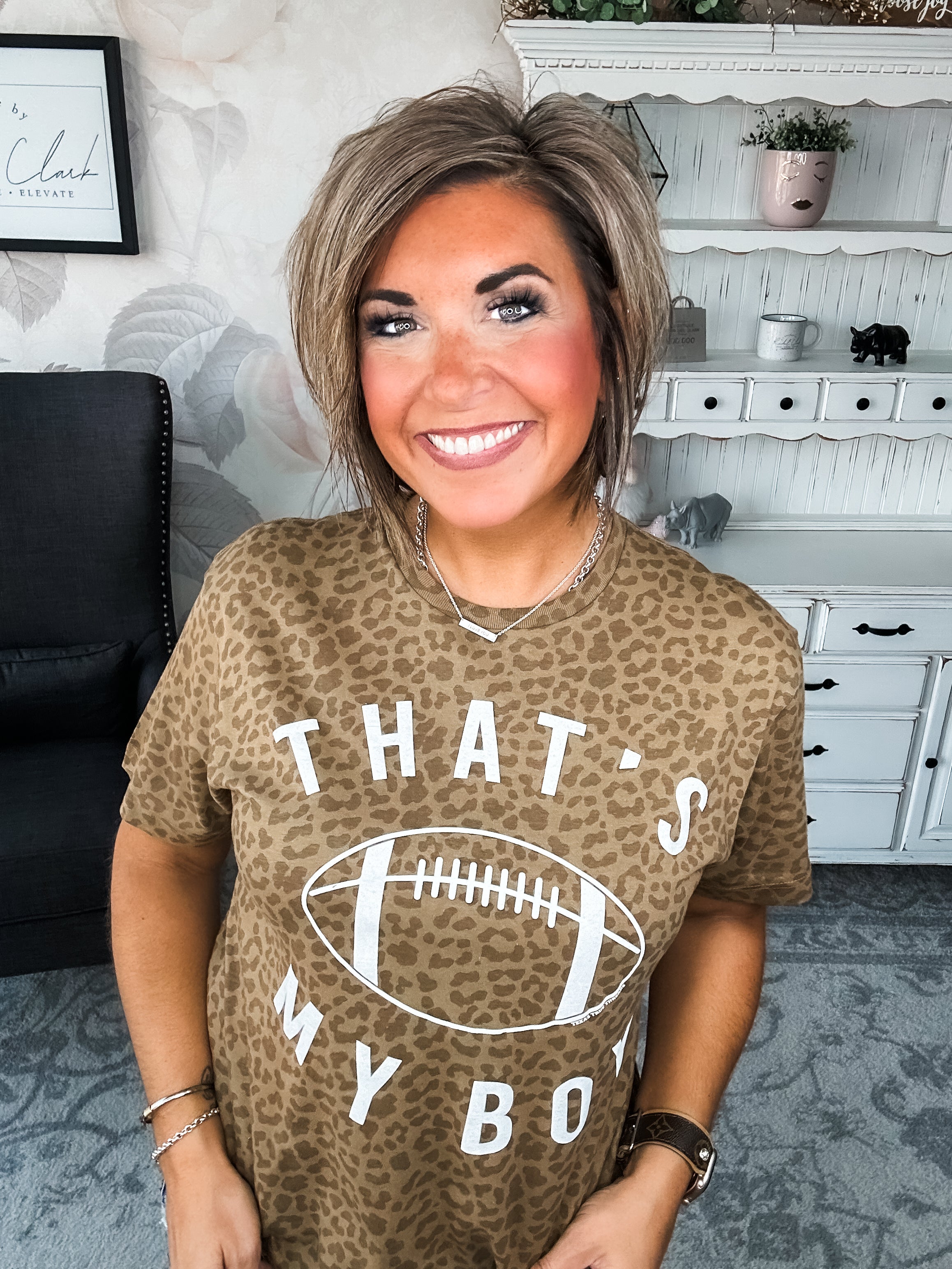 Woman wearing a leopard print t-shirt with 'That's My Boy' text and football graphic.