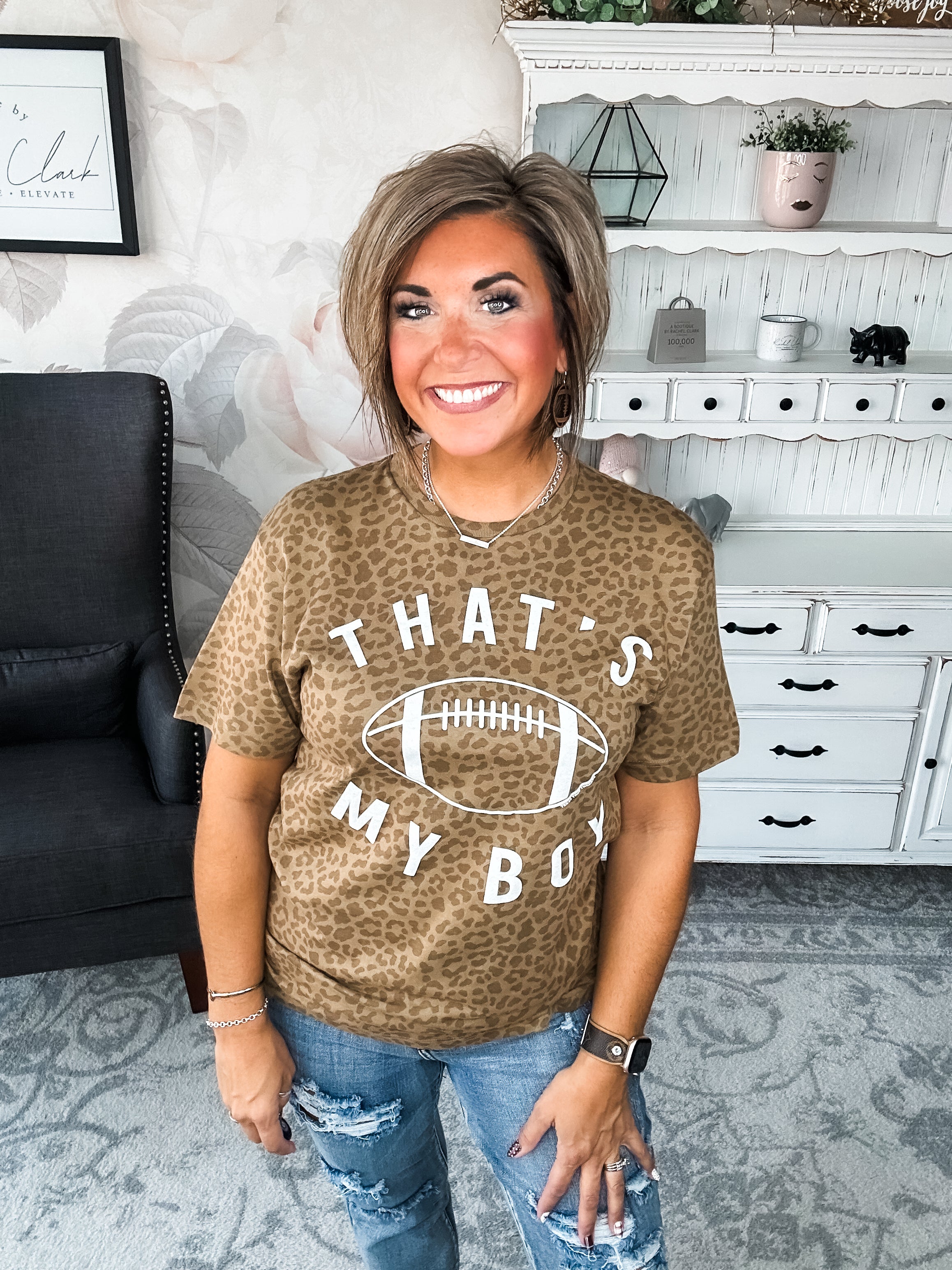 Woman wearing a leopard print t-shirt with 'That's My Boy' text and football graphic.